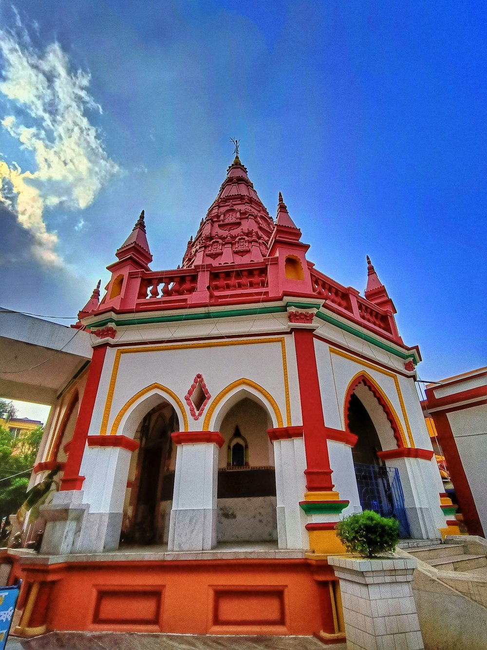 a red and white building with a sky background