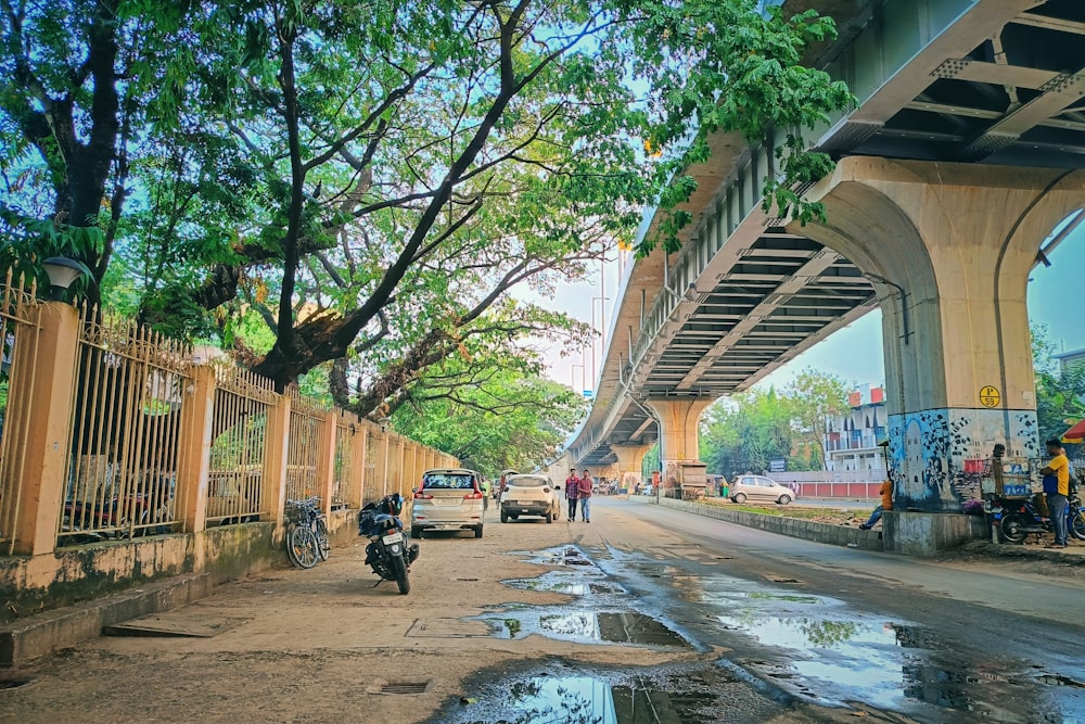 a man riding a motorcycle down a street next to a bridge