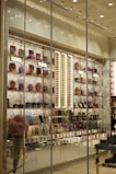 A brightly lit retail store display showcasing a variety of colorful packaged products. The shelves are filled with items like chocolates, candies, and gift boxes. Large glass windows allow a view of the interior, which is organized with sections labeled 'Bestsellers' and 'Heritage'. Decorative elements such as an oversized pink ice cream cone and elegant wallpaper enhance the visual appeal.