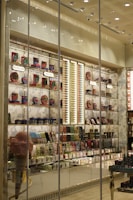 A brightly lit retail store display showcasing a variety of colorful packaged products. The shelves are filled with items like chocolates, candies, and gift boxes. Large glass windows allow a view of the interior, which is organized with sections labeled 'Bestsellers' and 'Heritage'. Decorative elements such as an oversized pink ice cream cone and elegant wallpaper enhance the visual appeal.