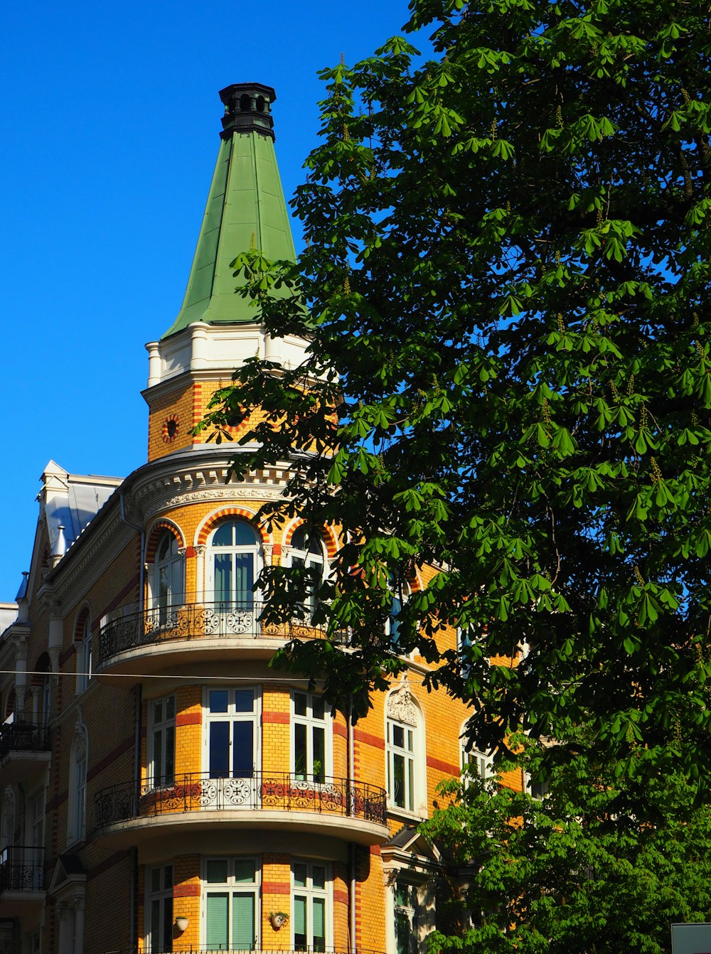 a tall building with a green roof and a clock tower