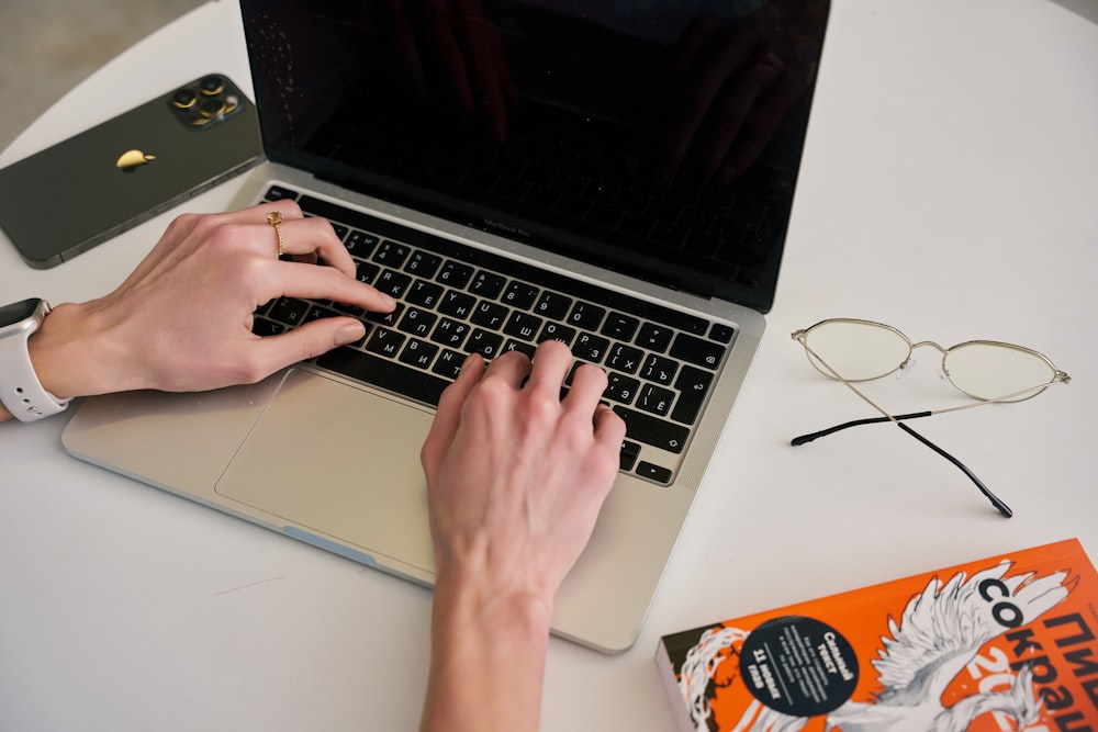 a person typing on a laptop on a table