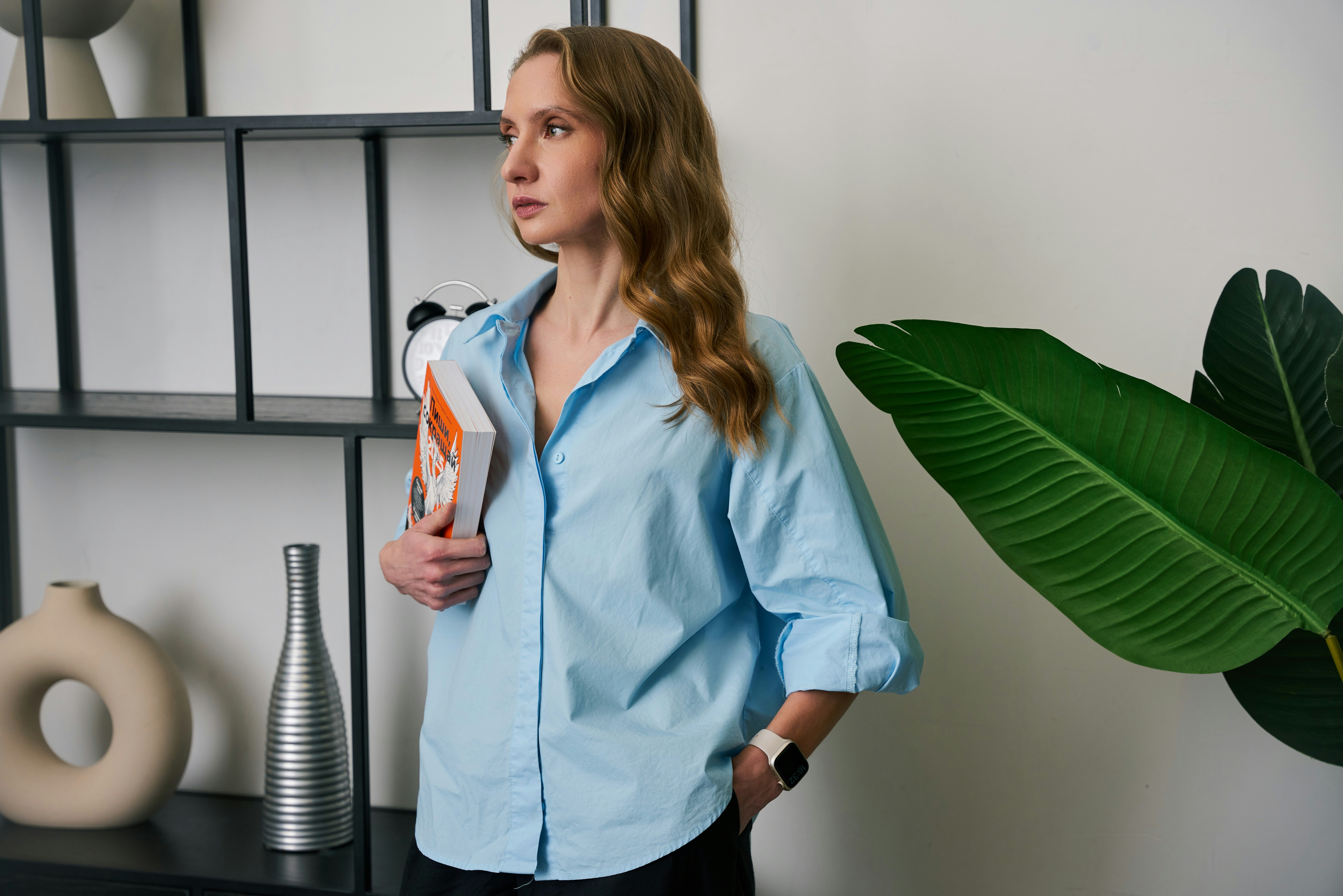 a woman standing in front of a shelf holding a bottle