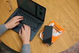 Close-up of Cory’s hands typing on a laptop with eBook drafts open.