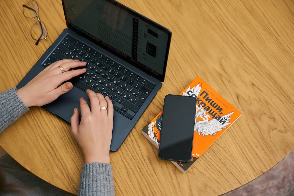 a person using a laptop on a wooden table