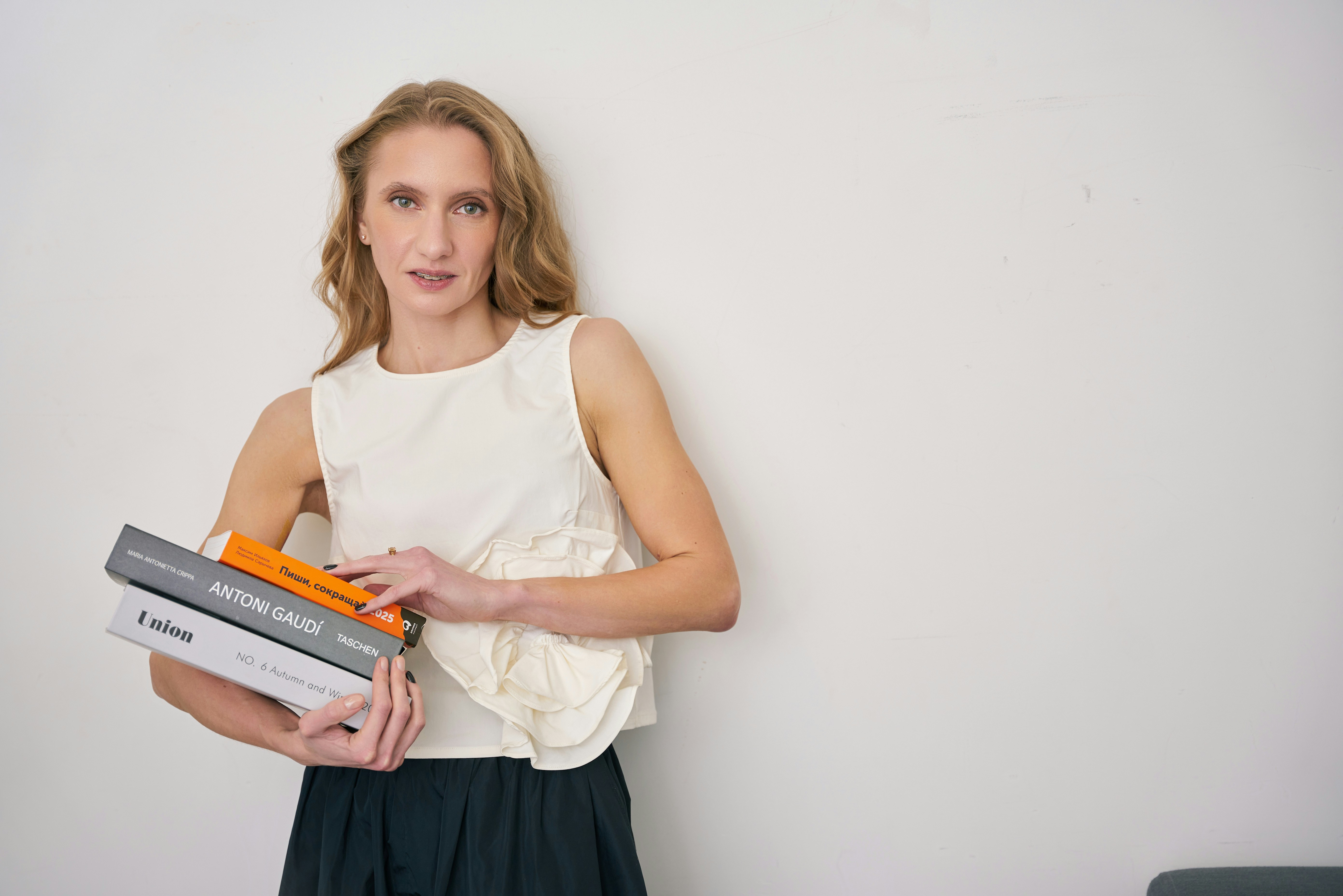 a woman holding a stack of books in her hands