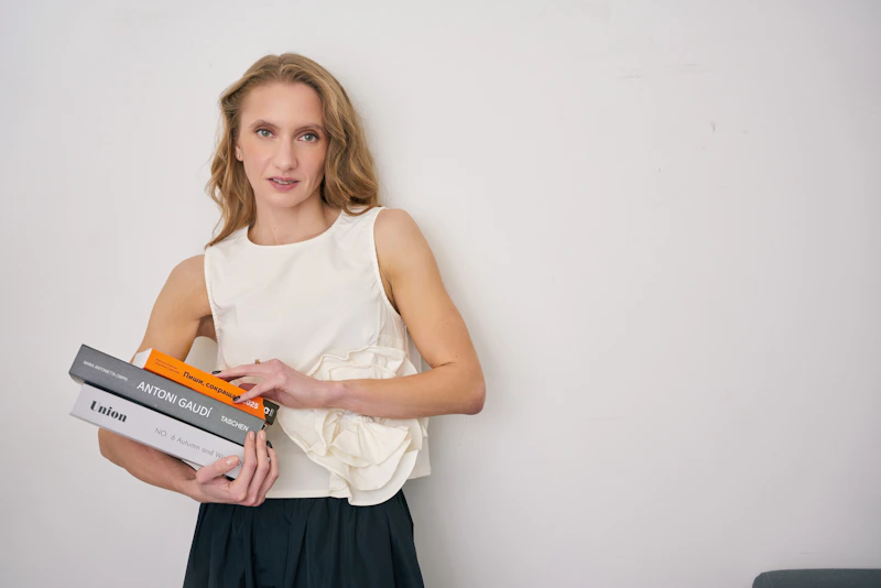 ambitious woman holding a stack of books