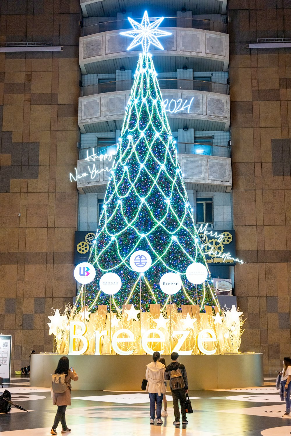 a christmas tree is lit up in front of a building