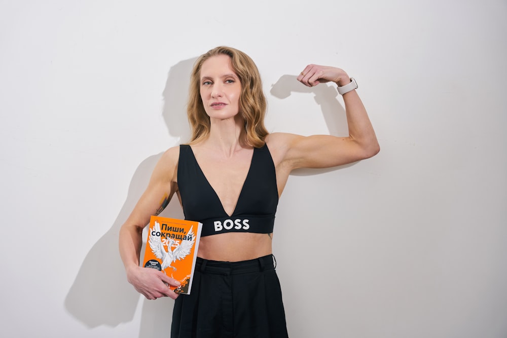 a woman holding a book and posing for a picture