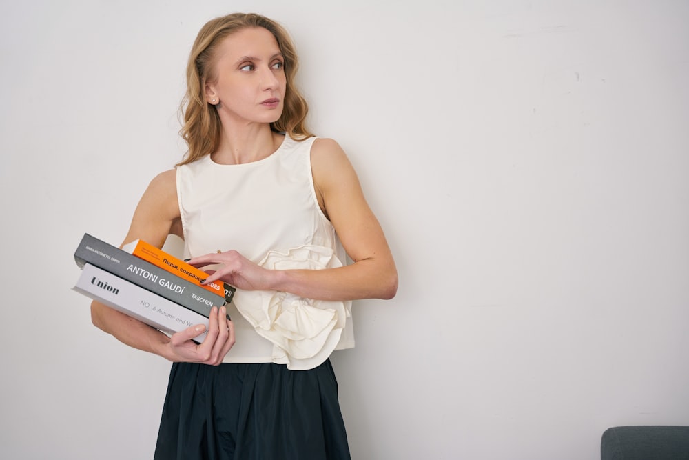 a woman holding a stack of books in her hands