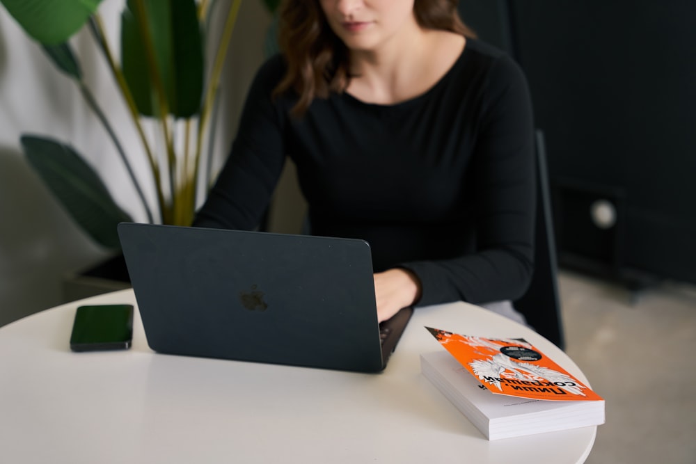 a woman sitting at a table with a laptop