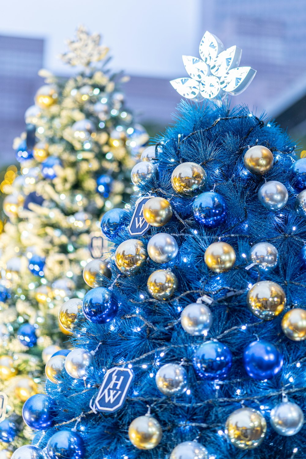 a blue christmas tree with gold and silver ornaments