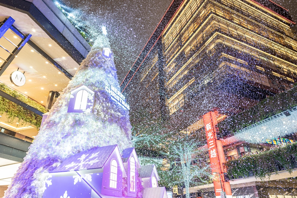 a christmas tree is lit up in the middle of a city
