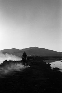A rugged cowboy on horseback against a golden desert sunset, embodying the spirit of the west.