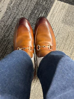 a person wearing blue jeans and brown shoes