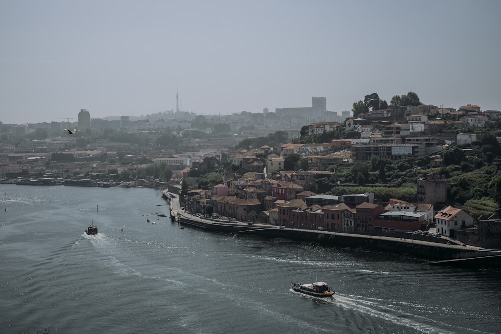 a boat traveling down a river next to a city