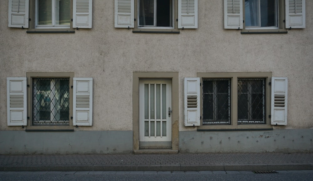 ein Gebäude mit weißen Fensterläden und einer weißen Tür