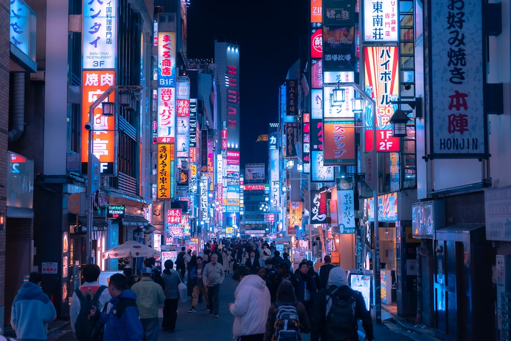 a group of people walking down a street at night