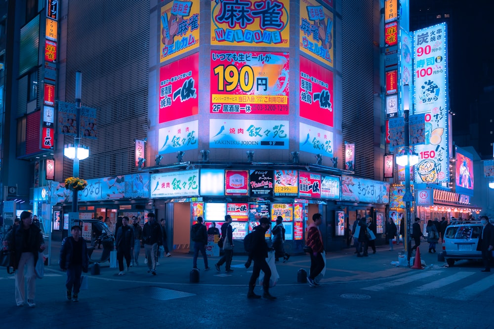 a group of people walking around a city at night