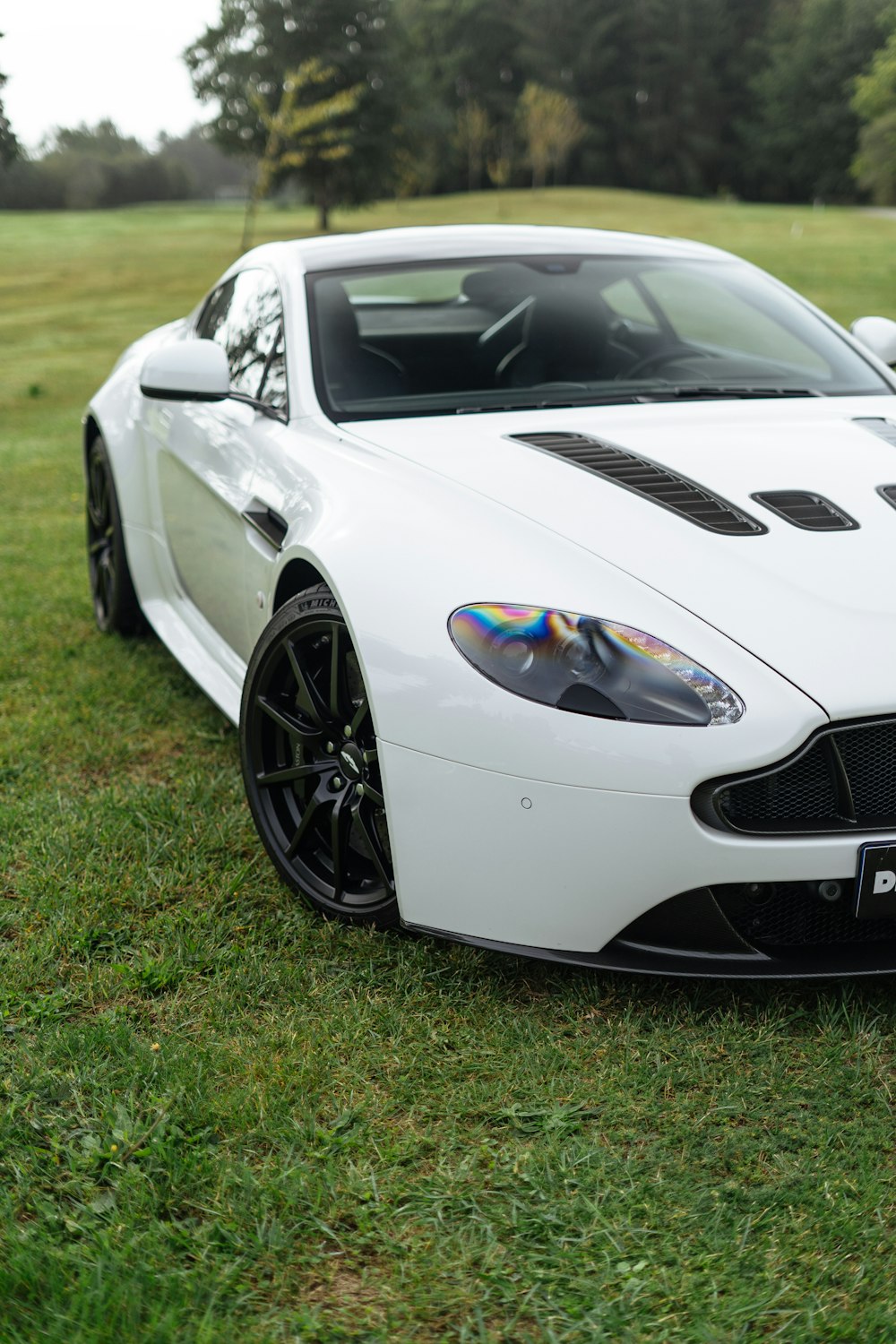 a white sports car parked in the grass