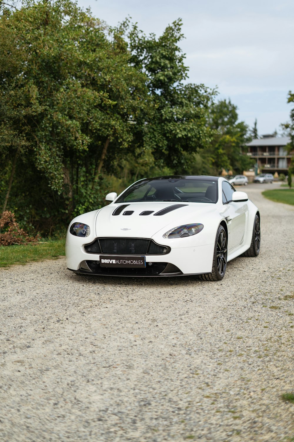 a white sports car parked on a gravel road