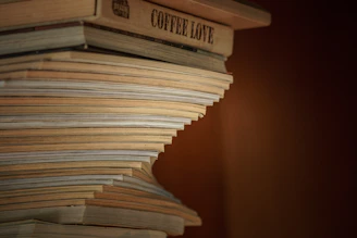 Stack of colorful ebooks and PDFs ready for download on a wooden desk with a cup of coffee.