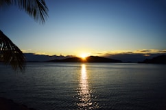 the sun is setting over a body of water