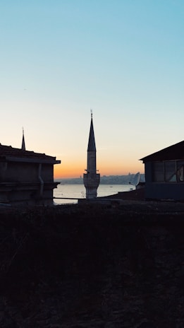 A calm sunset view over a minaret silhouetted against a golden sky.