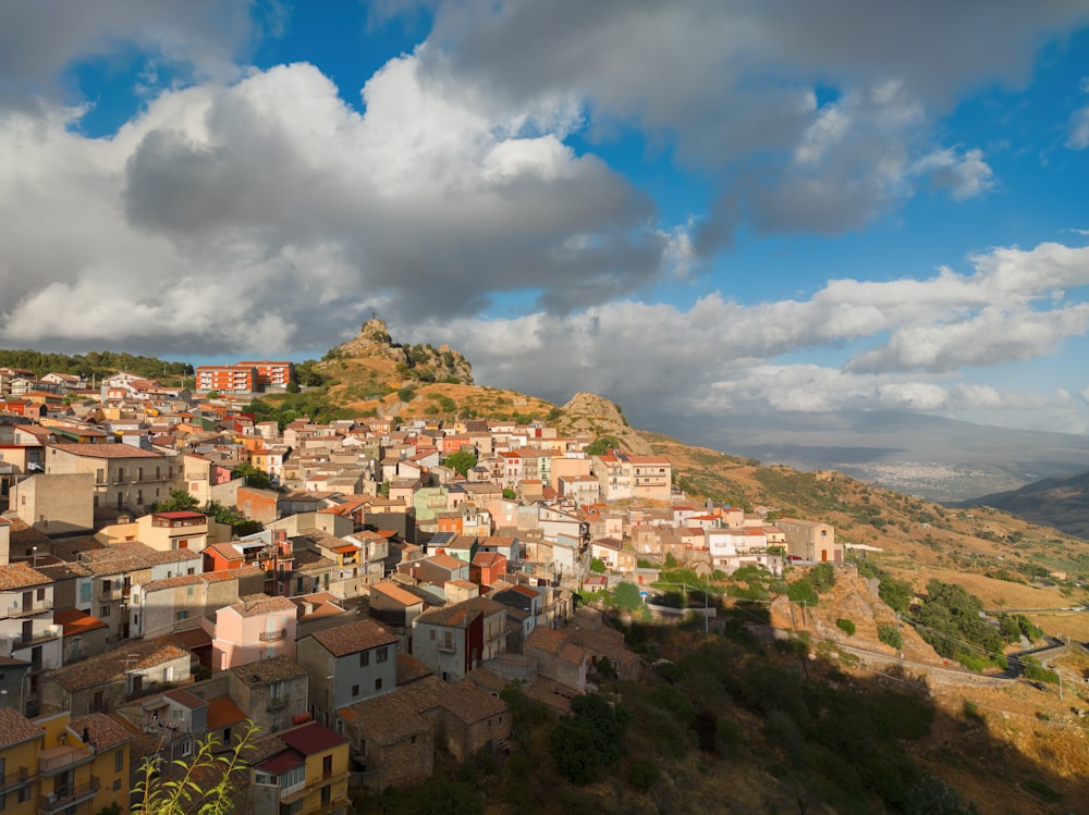 a small village nestled on a hill under a cloudy sky