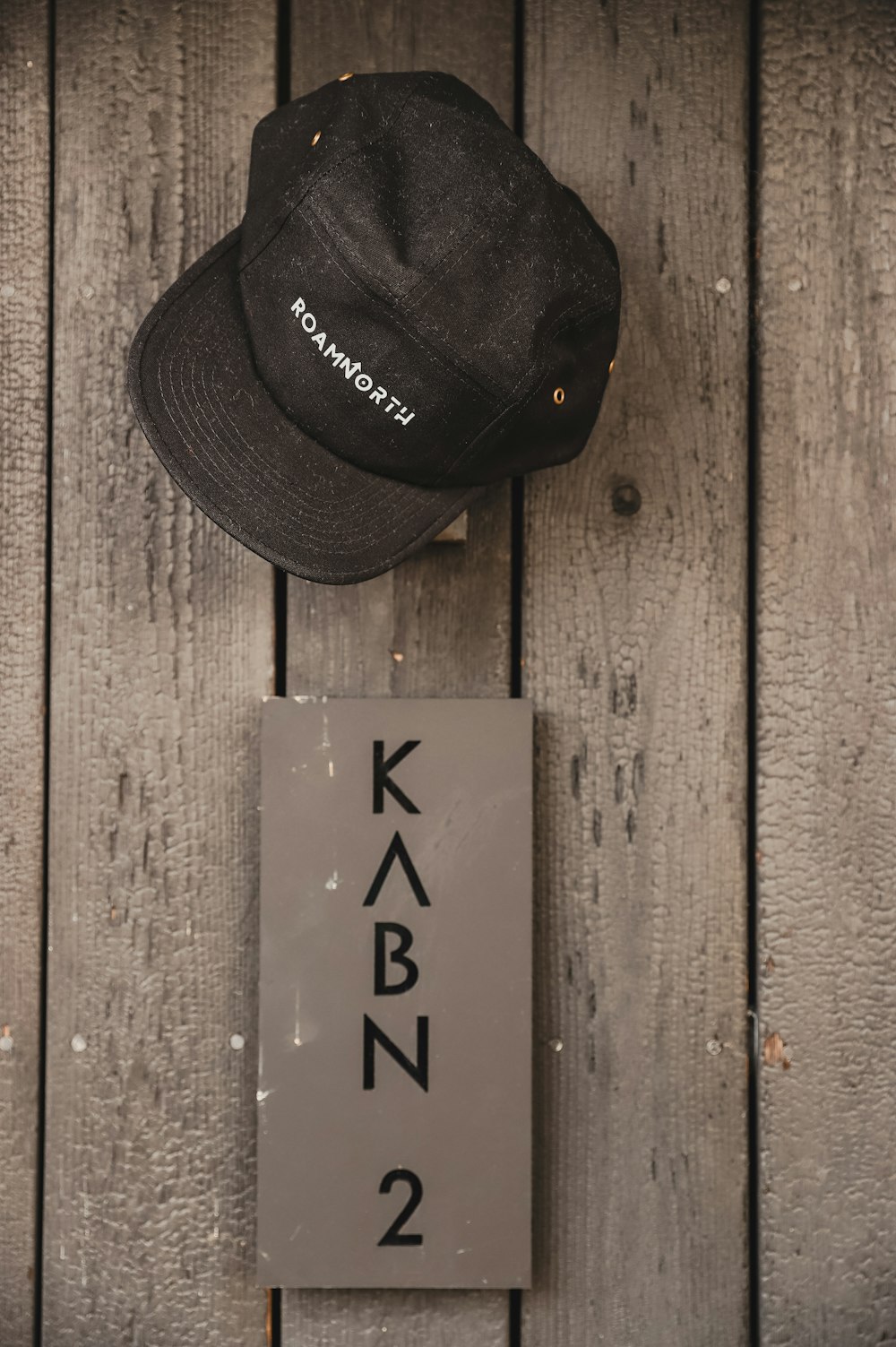 a hat and a sign on a wooden wall