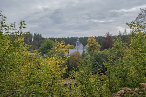 A serene landscape showing a church building surrounded by nature.