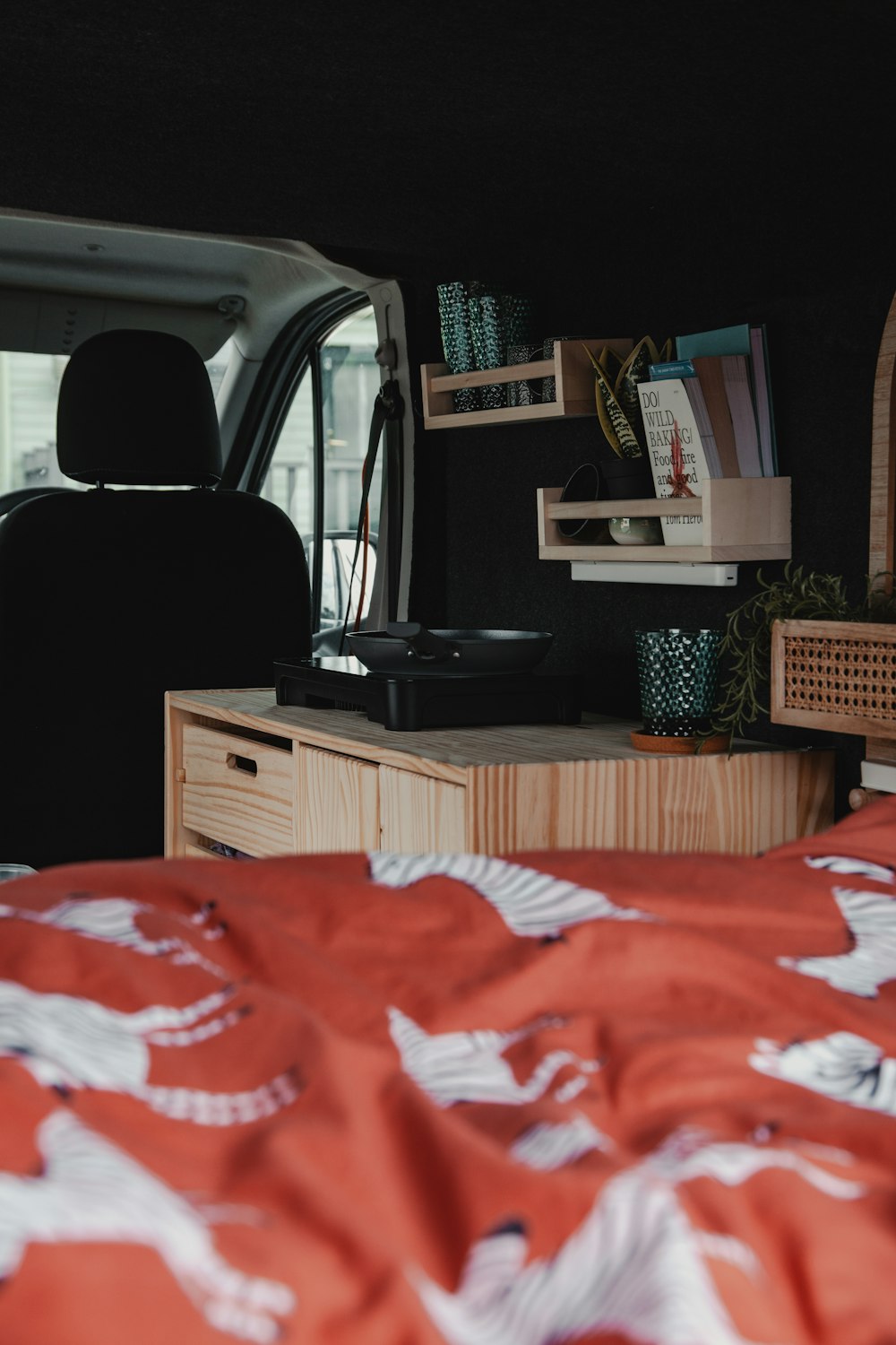 a bedroom with a bed and a desk in the back of a van