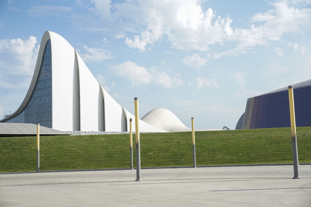 a large white building sitting on top of a lush green field