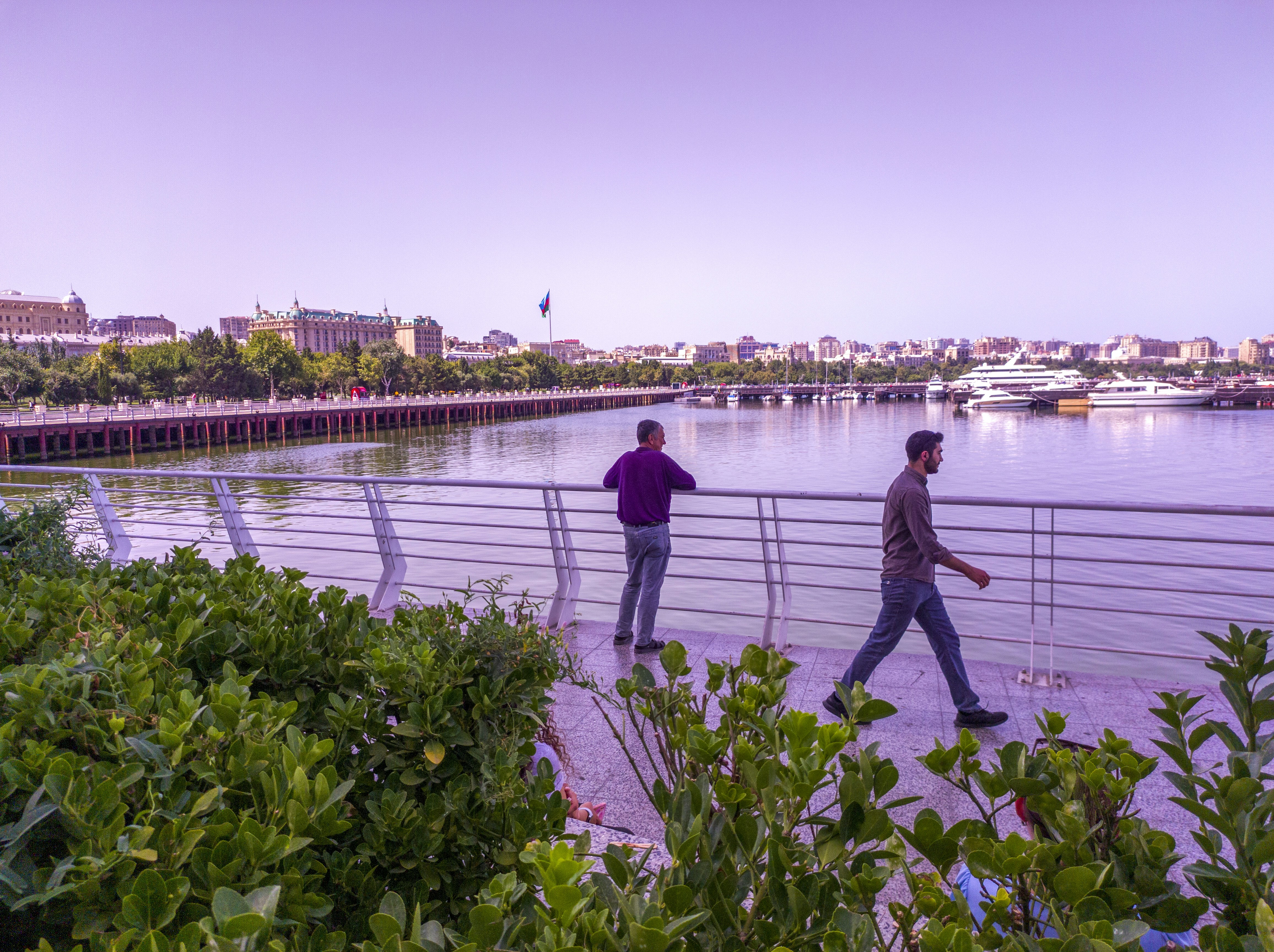 a couple of men walking across a bridge over a river, 