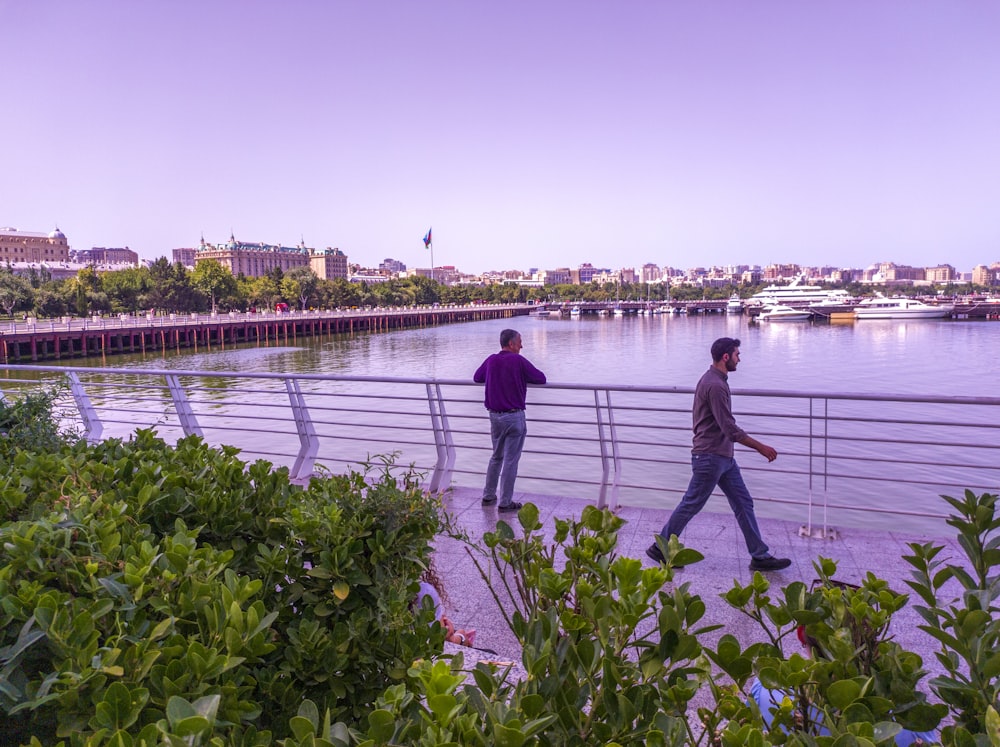 Un par de hombres caminando a través de un puente sobre un río