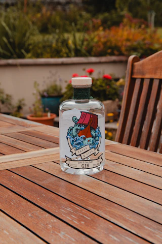 Bottles of Zephyrus Kiss Gin, Pinnacle Gin, and Pinnacle Rum lined up with the sea in the background.