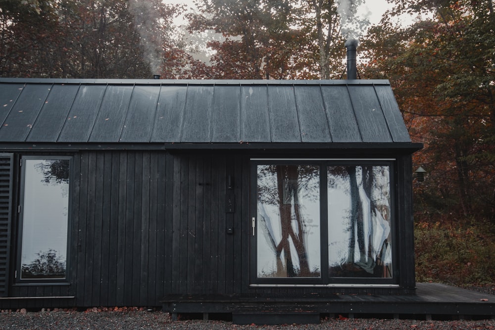 a small black cabin with a metal roof