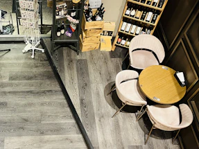 A cozy winery tasting room with a group gathered around a wooden table sharing wine and conversation