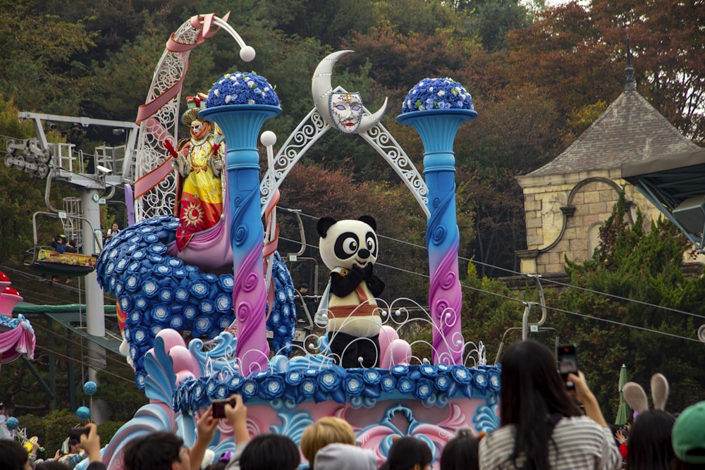 a parade float with a panda sitting on top of it