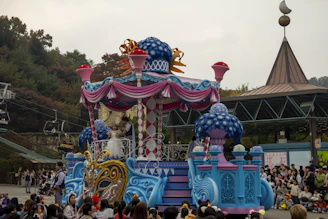 a colorfully decorated carnival float in front of a crowd of people