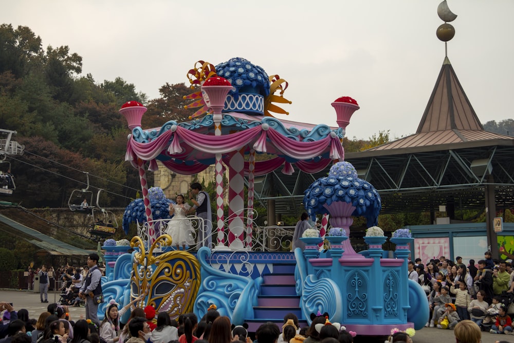 Un carro di carnevale colorato di fronte a una folla di persone