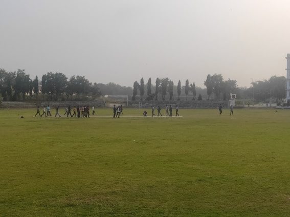 A lively group photo of Beijing Cricket Club members celebrating on the pitch under a clear blue sky.