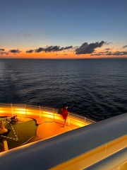 Professional seafarers working on a ship deck during sunset.