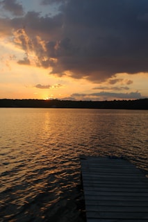 A warm sunset over a quiet lake reflecting golden hues
