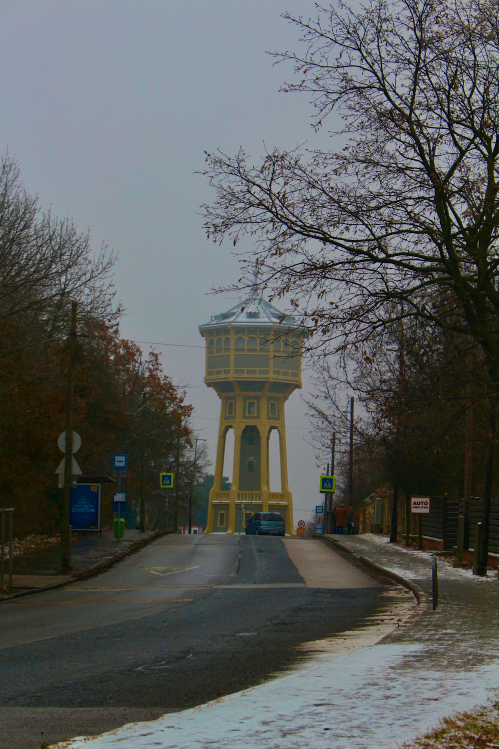 a yellow water tower sitting on the side of a road