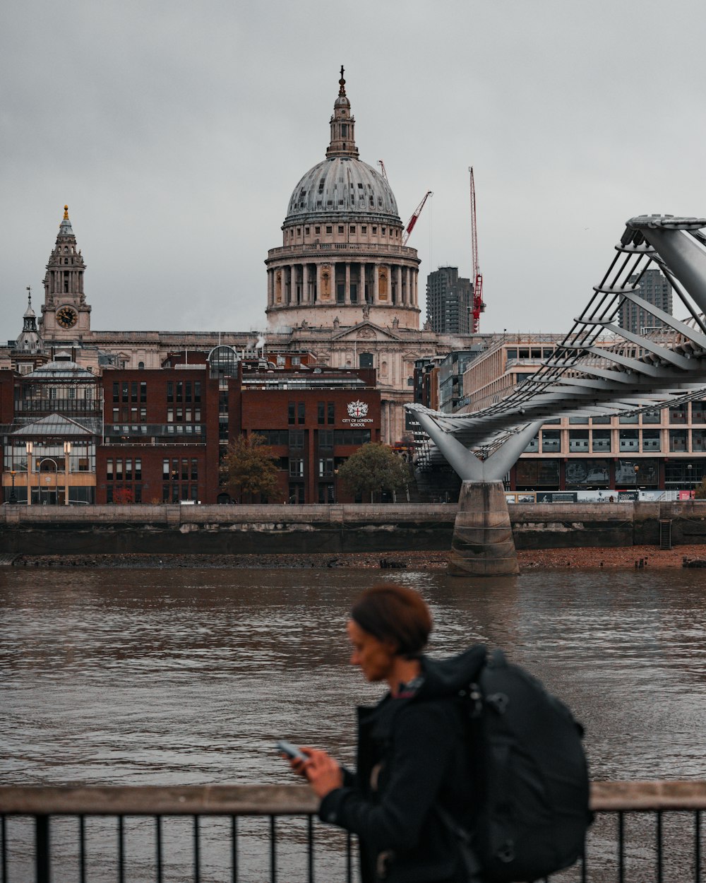 Une femme marchant sur un pont avec un téléphone portable à la main