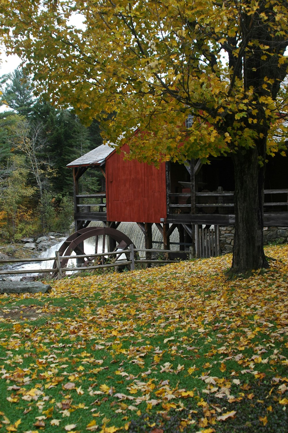 a red building with a water wheel in front of it