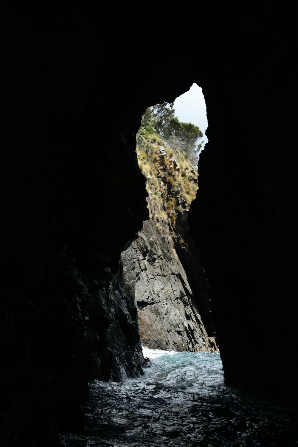 a view of a body of water through a cave