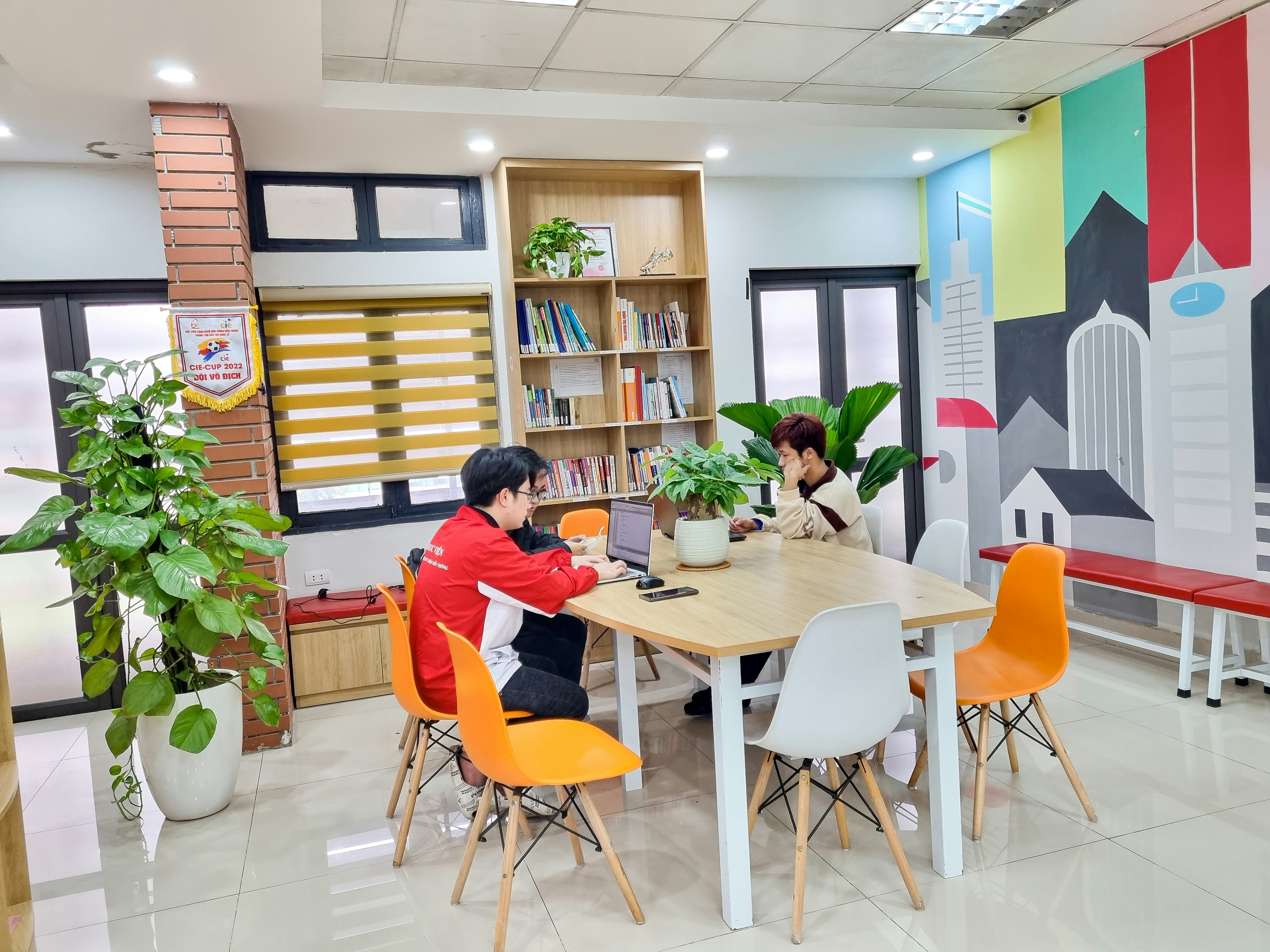 Two people having a focused online conversation on a laptop, bright study setting, collaborative and engaged atmosphere