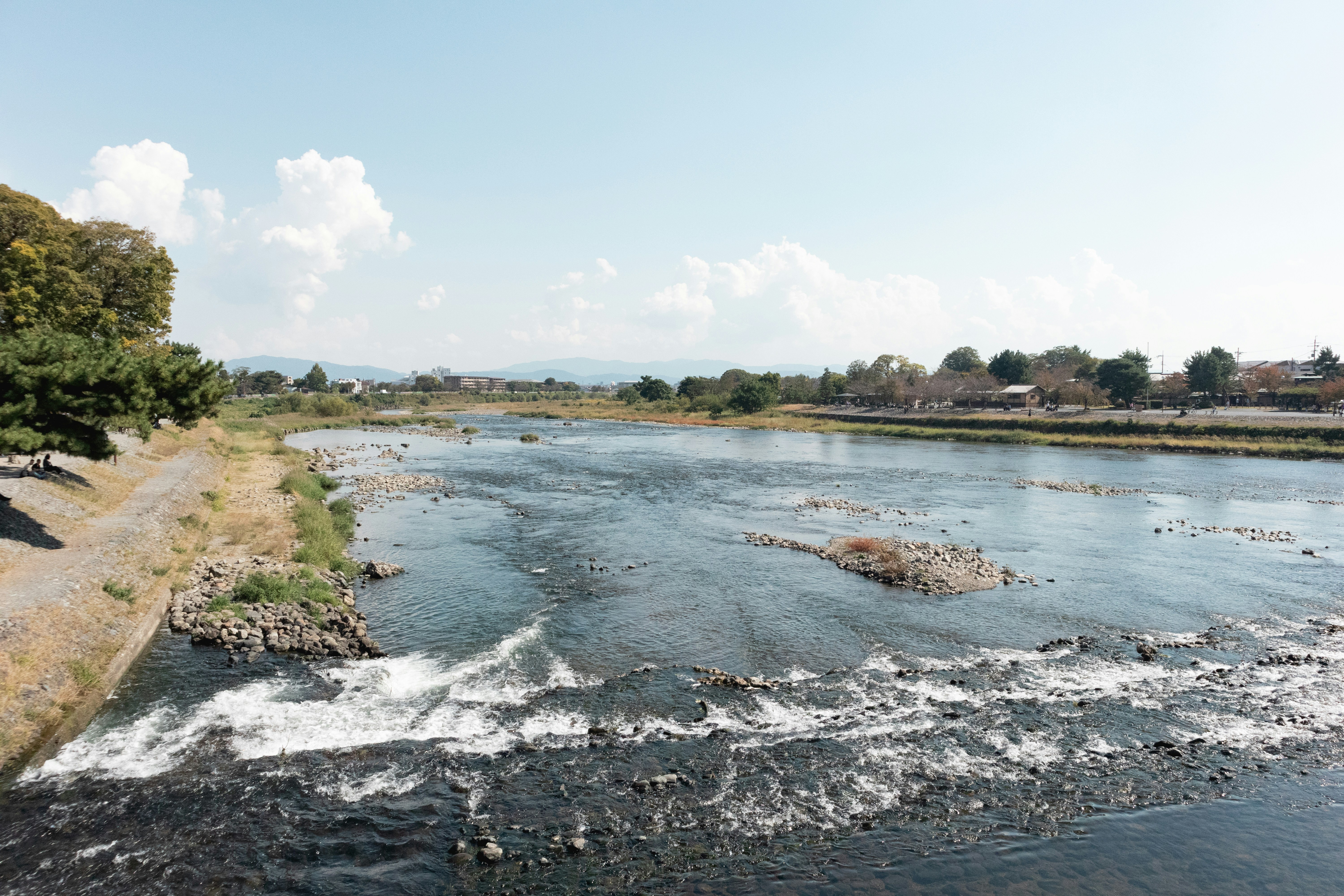 a river running through a lush green countryside, 
